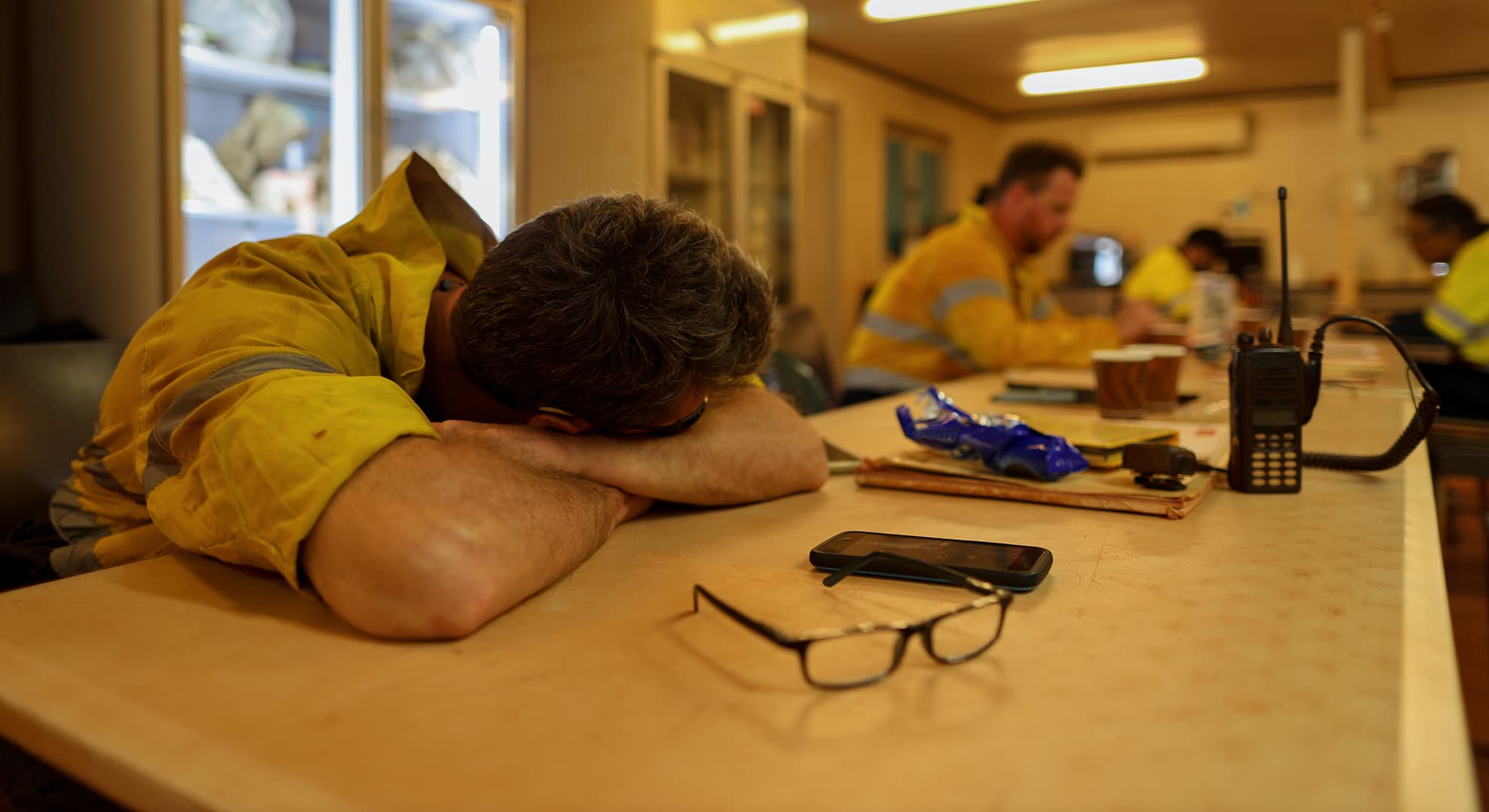 Mine worker laying his head on a table.