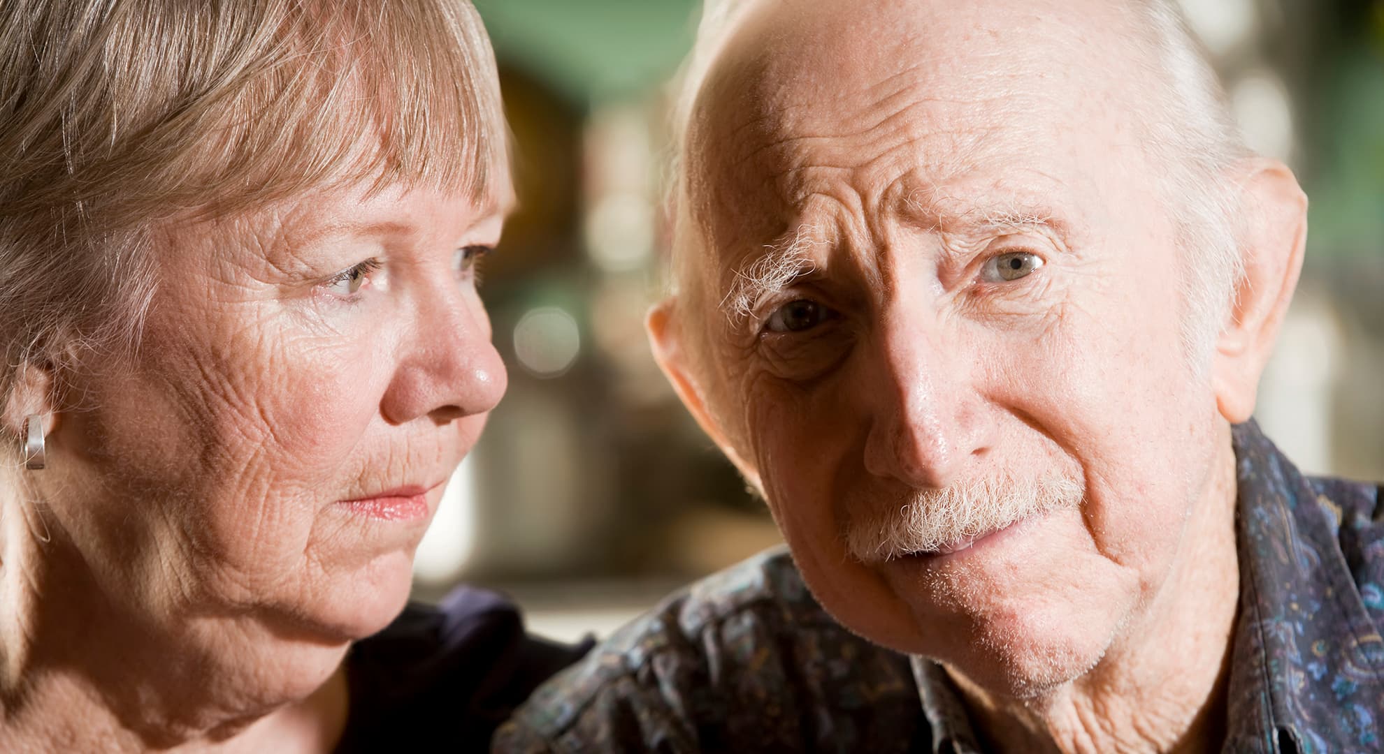 Older woman looking worriedly at older man.