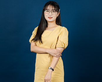 Dr Clare Jing Tai in front of a navy blue background