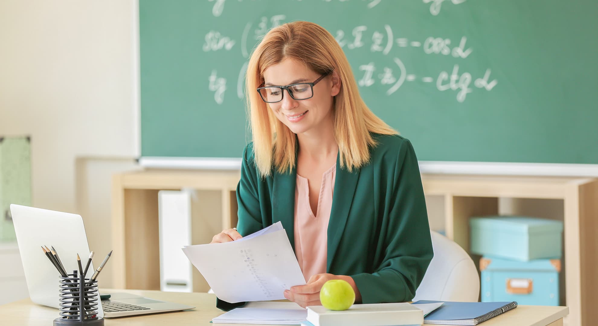 Teacher sitting at desk smiling