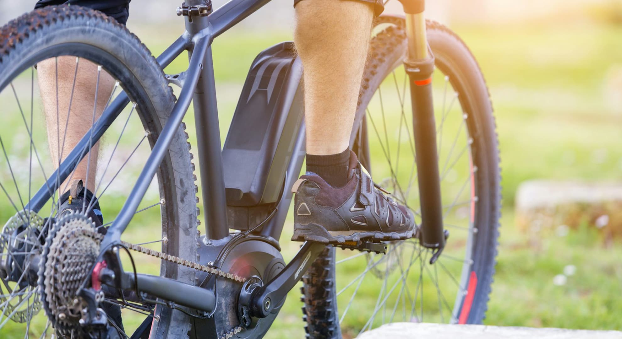 Close-up of man's feet and a bicycle.