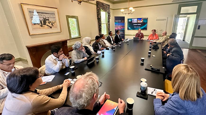 A group of researchers sit at a conference table having a discussion.
