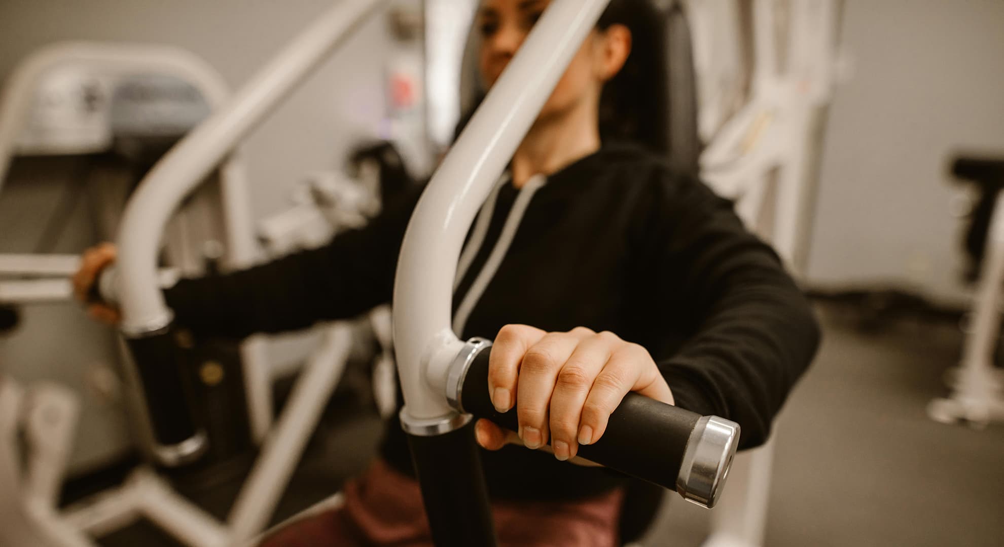 Woman on a weight train machine.
