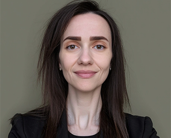Image of a woman with straight dark brown hair in a black blouse