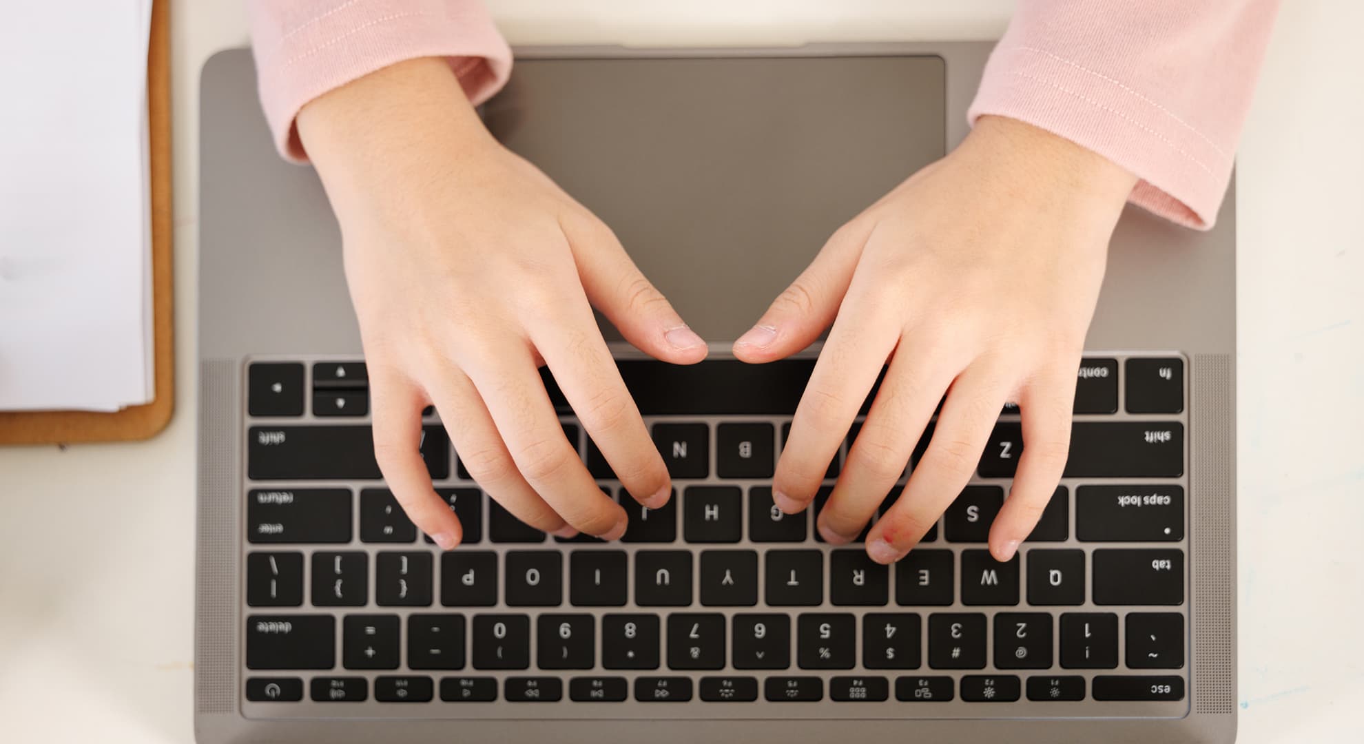 Child's hands over keyboard.