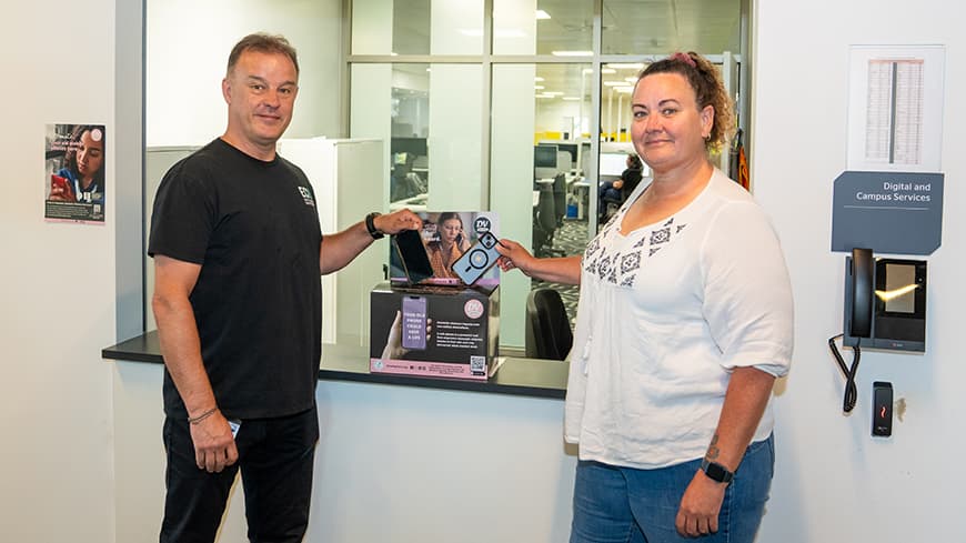 Two people holding phones and putting them in a box.