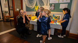 Early Childhood pre-service teacher in class with four students