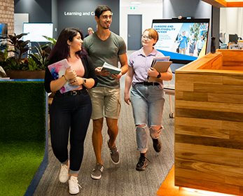 Three students walk through a collaborative learning space. Explore the Learning and Career Hub at Joondalup Library.