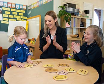 primary school scene with your female teacher and two students