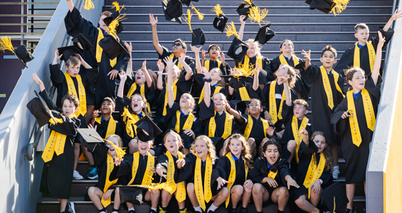 Children wearing graduation gowns and hats