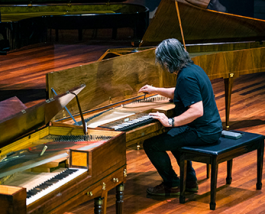 A person playing an historic piano.