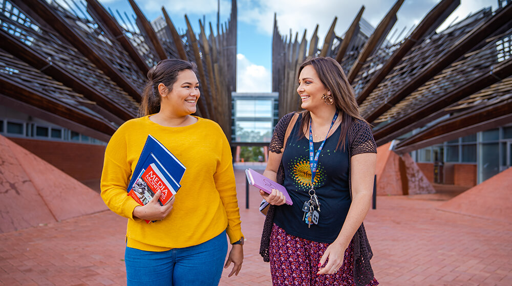 Two students walking in front of building 1 at the ECU Joondalup campus.