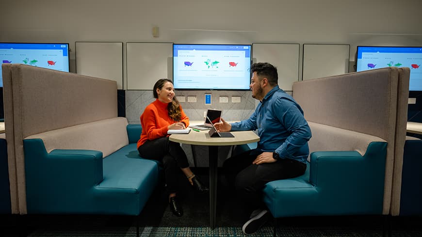 A male and female student having a discussion in a modern university facility