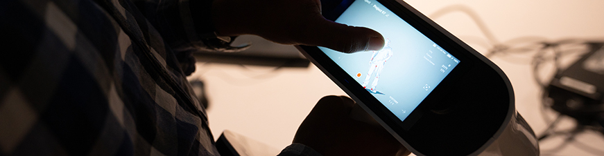 Man looking at small hand held electronic device.