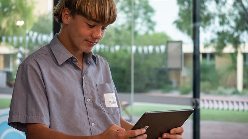 Male teenage high school student using MIApp on a tablet device.
