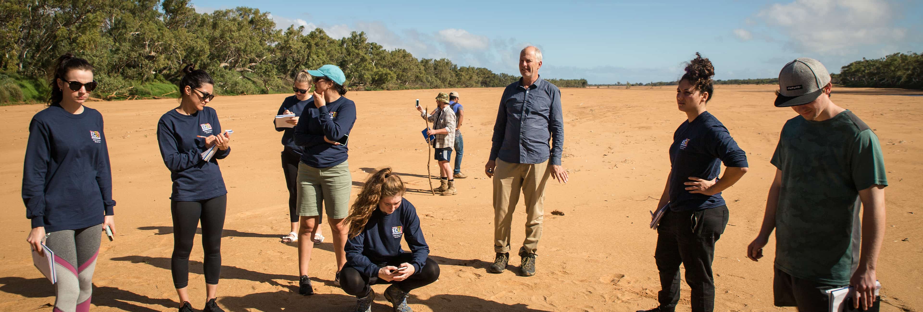 Students and lecturer standing on sandy ground in Canarvon