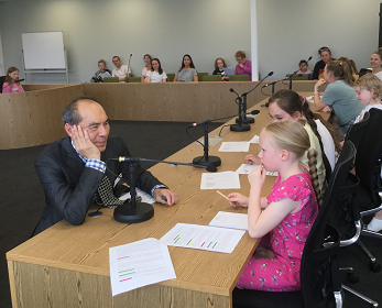 Law lecturer listening to child in moot court