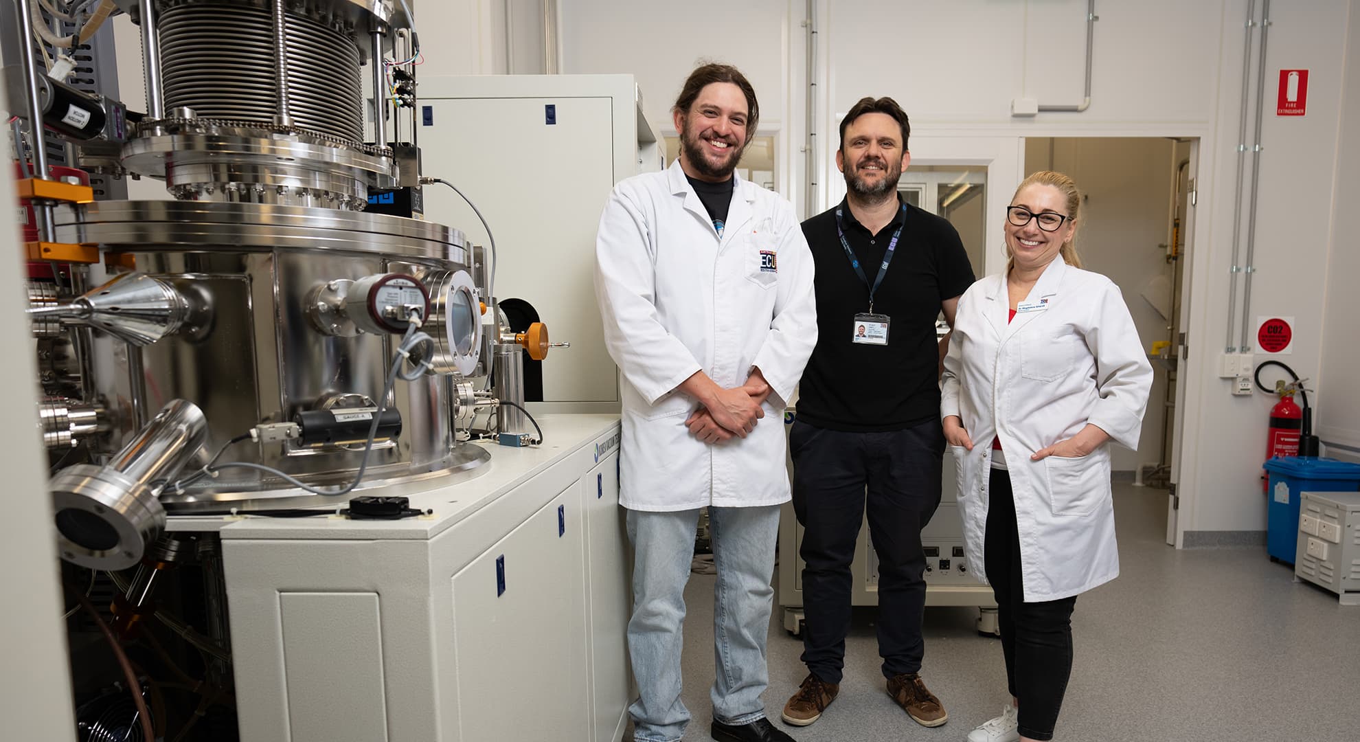 Three ECU scientists stand inside the new Spectroscopy and Surface Science Research Facility.