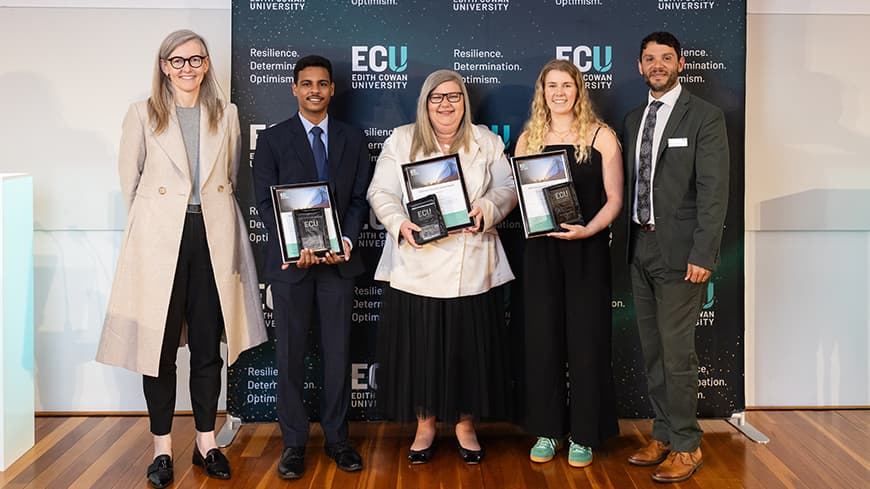Group of people standing in a line with awards.