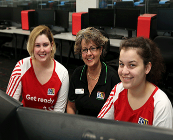 Dr Michelle Ellis working with two women in a computer lab