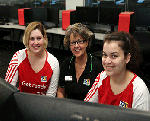 Dr Michelle Ellis working with two women in a computer lab
