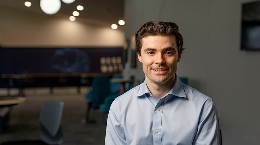 Hugh Barrington wears a light-blue button-up shirt and grins.