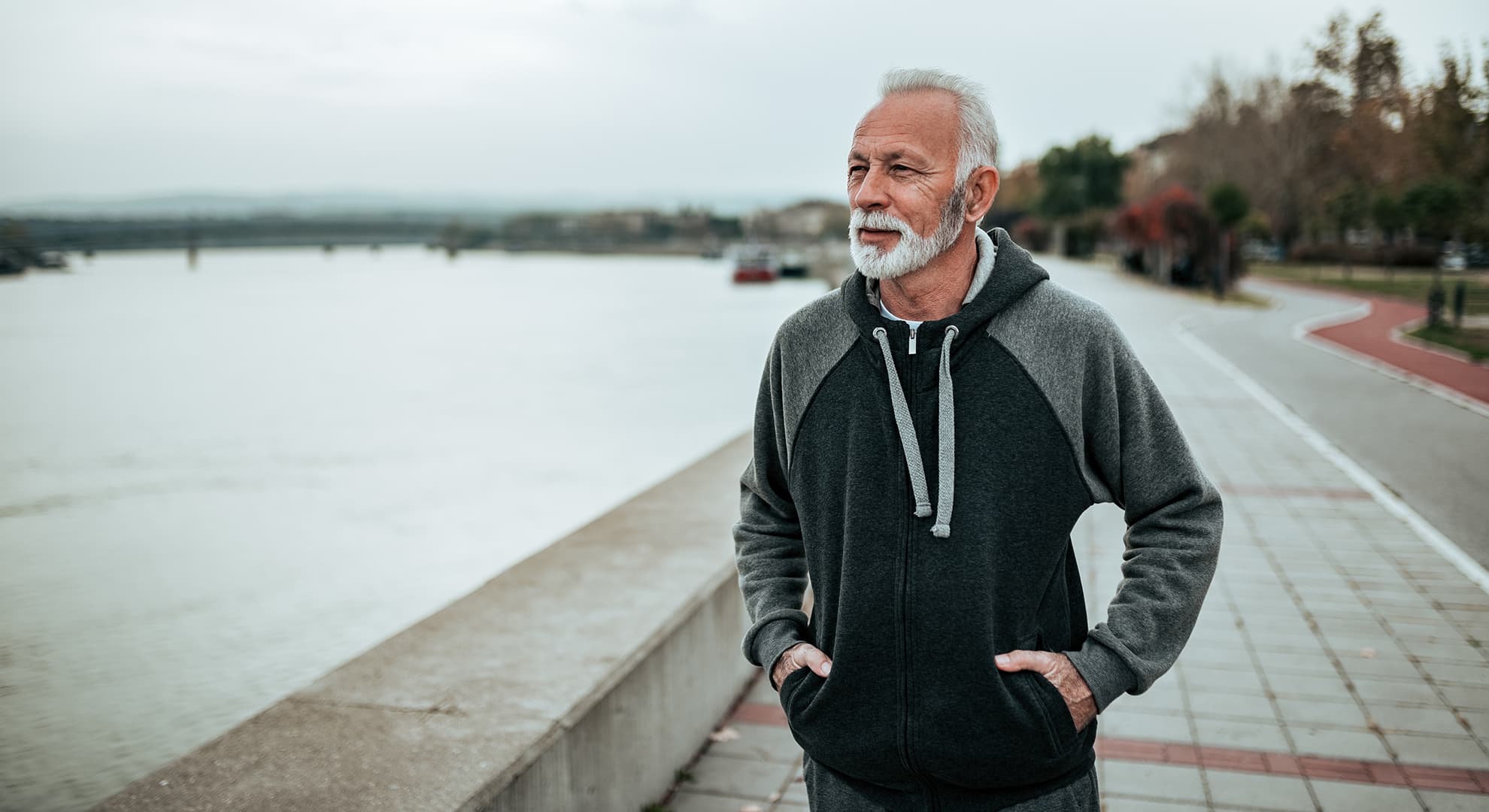 Older man by river overlooking the water.