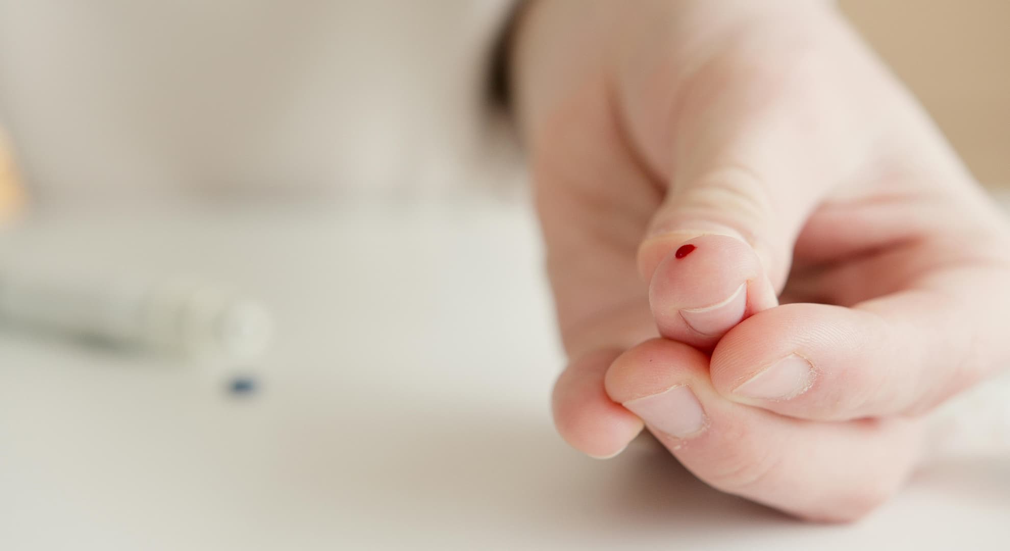 Finger with a drop of blood.