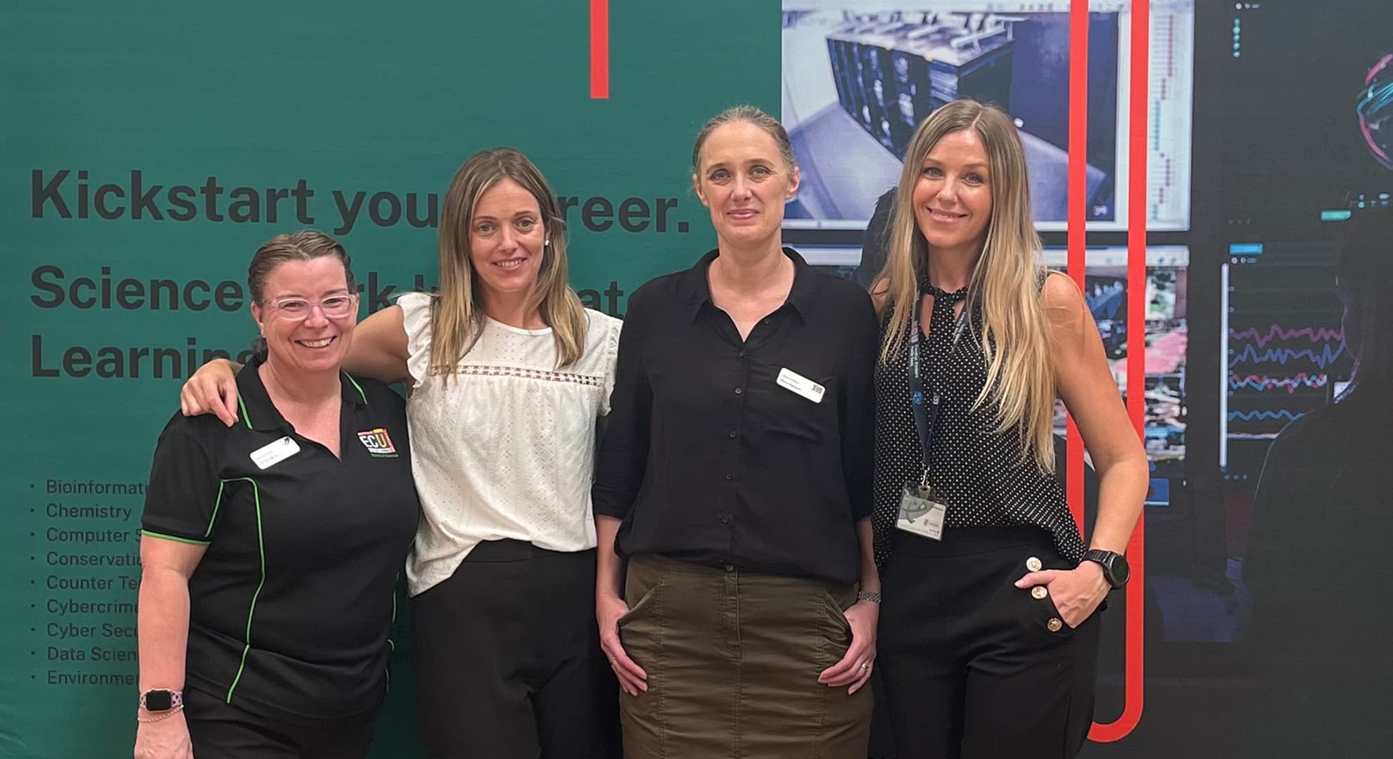 Four female staff standing together at ECU's Career's Fair