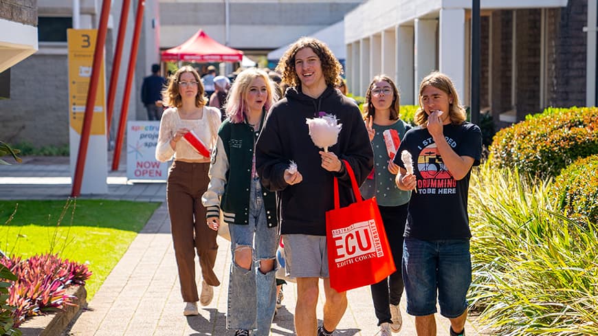 A group of young prospective students visit ECU Open Day eating pink fairy floss.