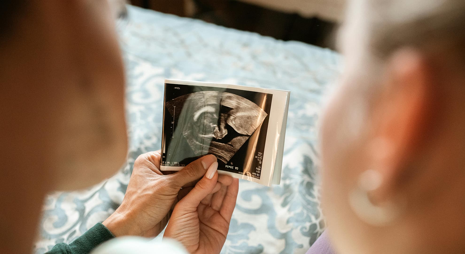 Man and woman holding sonogram picture.