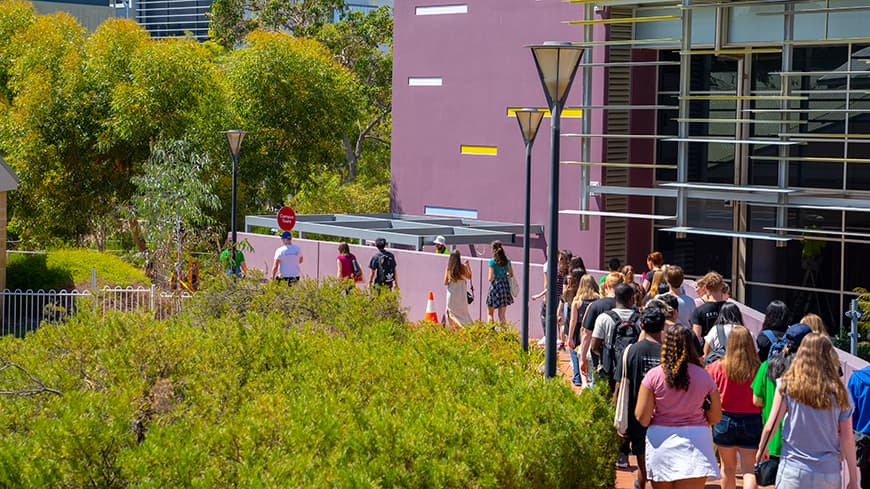 Group of students following a tour guide on university campus