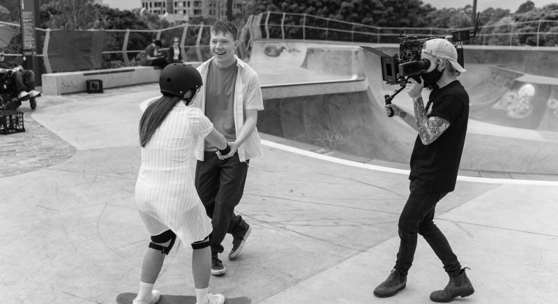 Man filming two people at a skate park