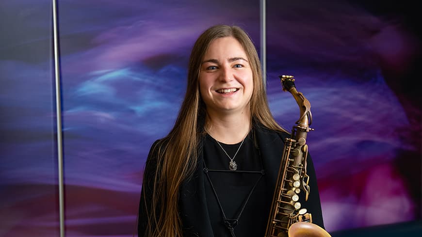 Photograph of PhD candidate Nikki Demandolx with saxophone.