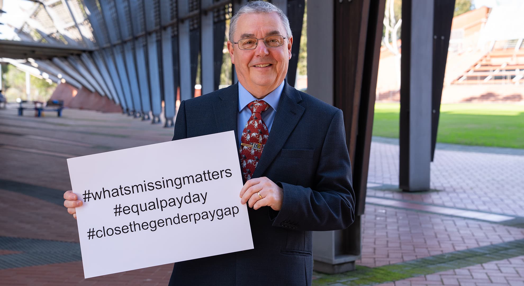 ECU Vice-Chancellor Professor Steve Chapman holding a sign with the hashtags what's missing matters, equal pay day and close the gender gap.