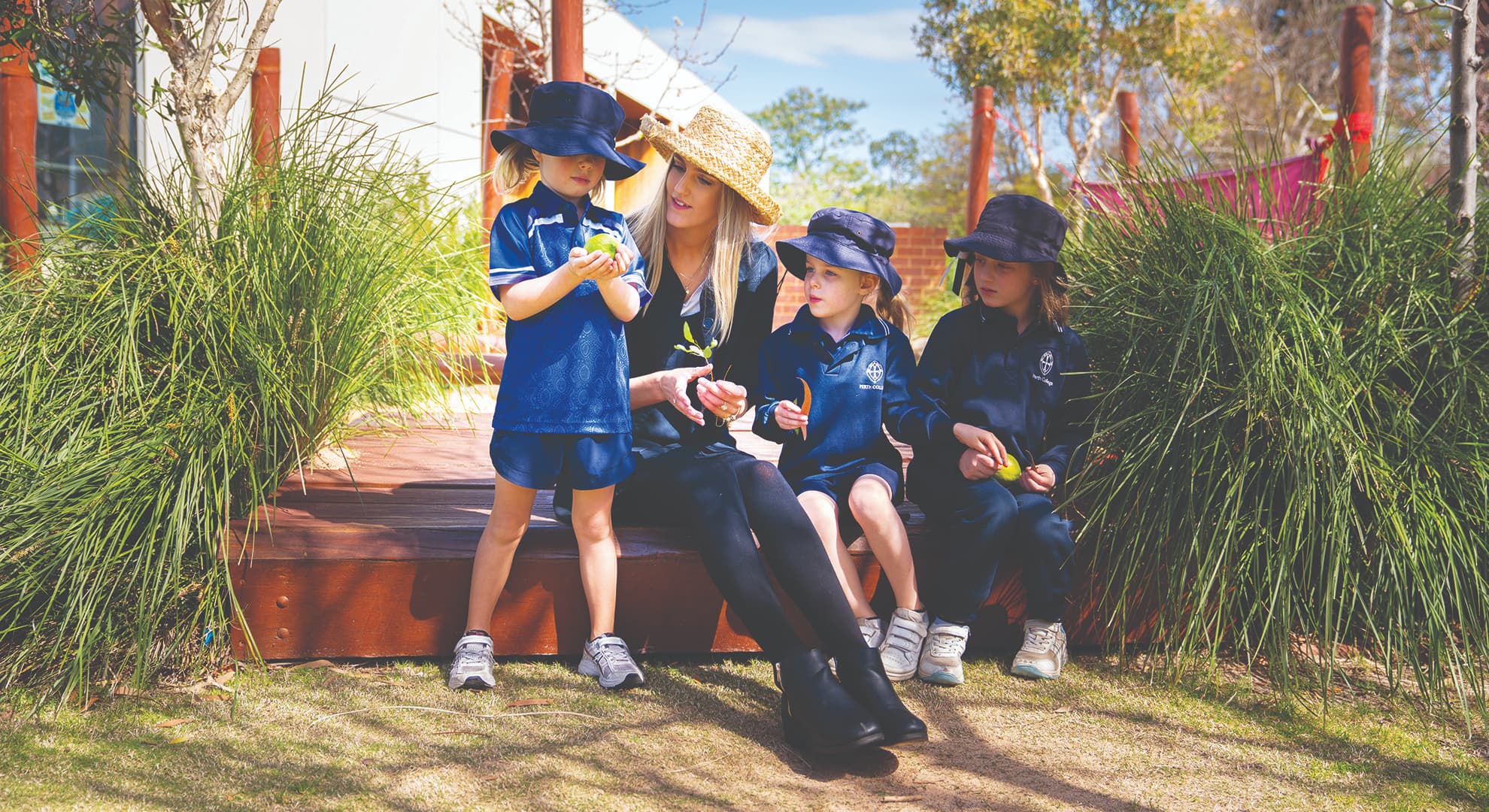 Teacher sitting with students on school grounds