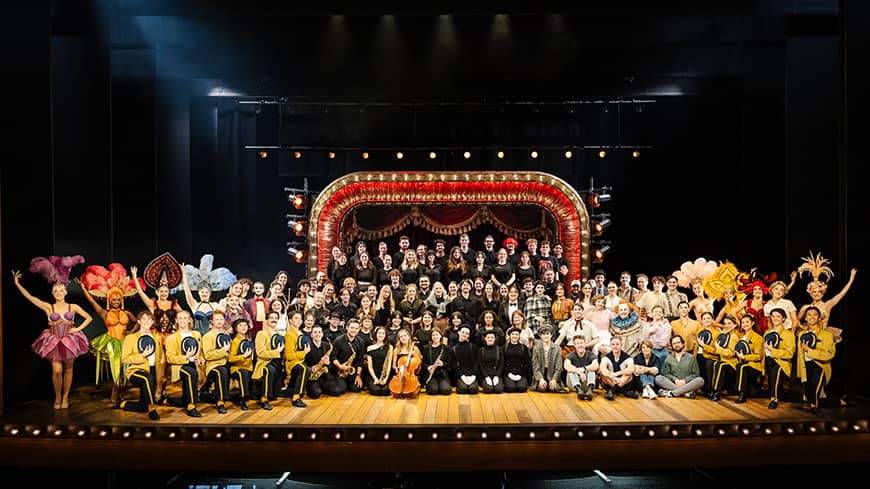 A large group of theatre cast posing for a photo