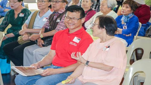Two people sitting amongst an audience facing a stage