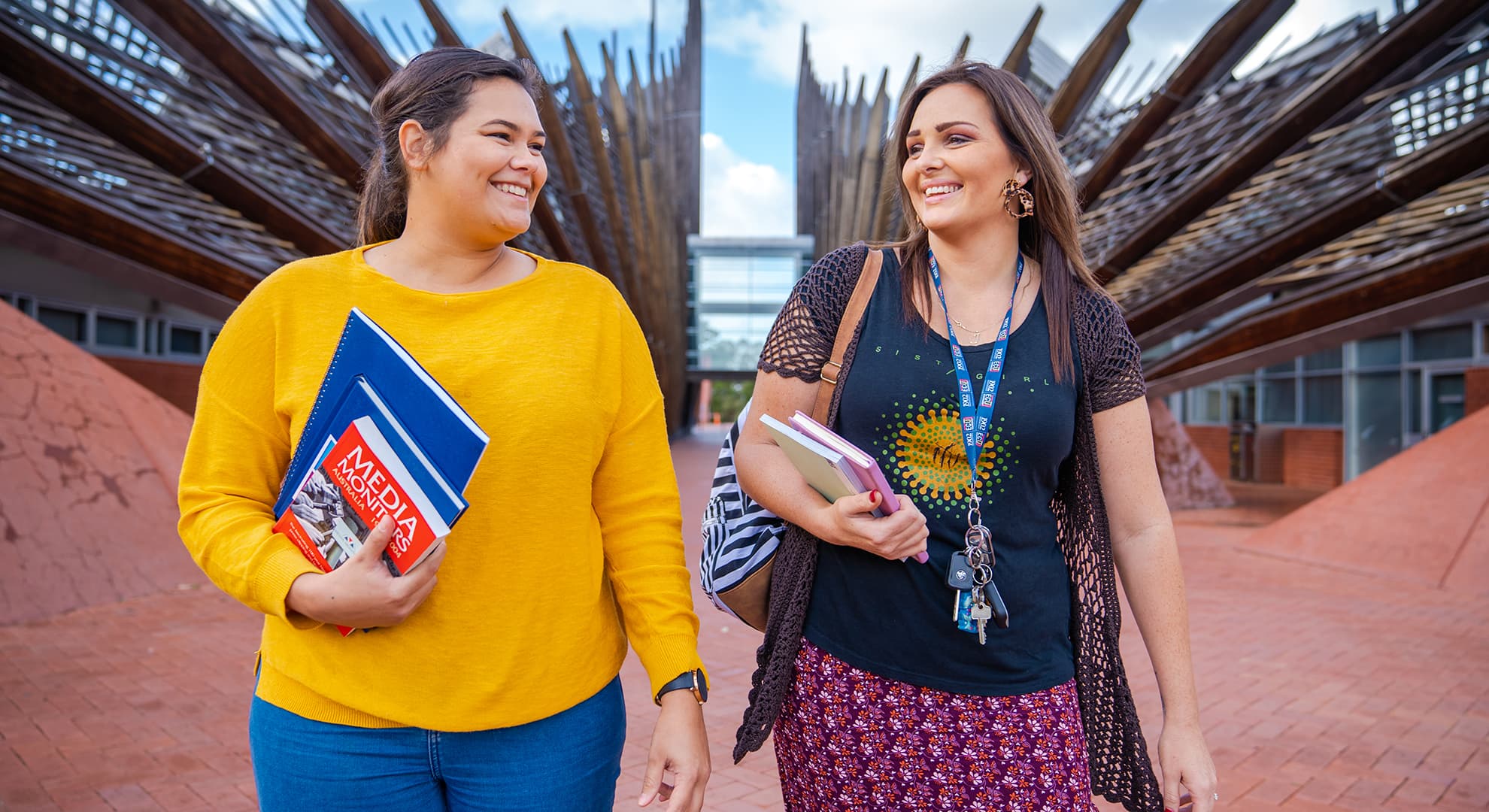 Two women walking in front of ECU's Building 1.
