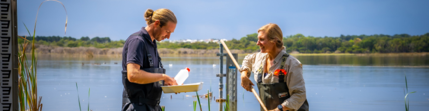 Two researchers finding specimens in water.