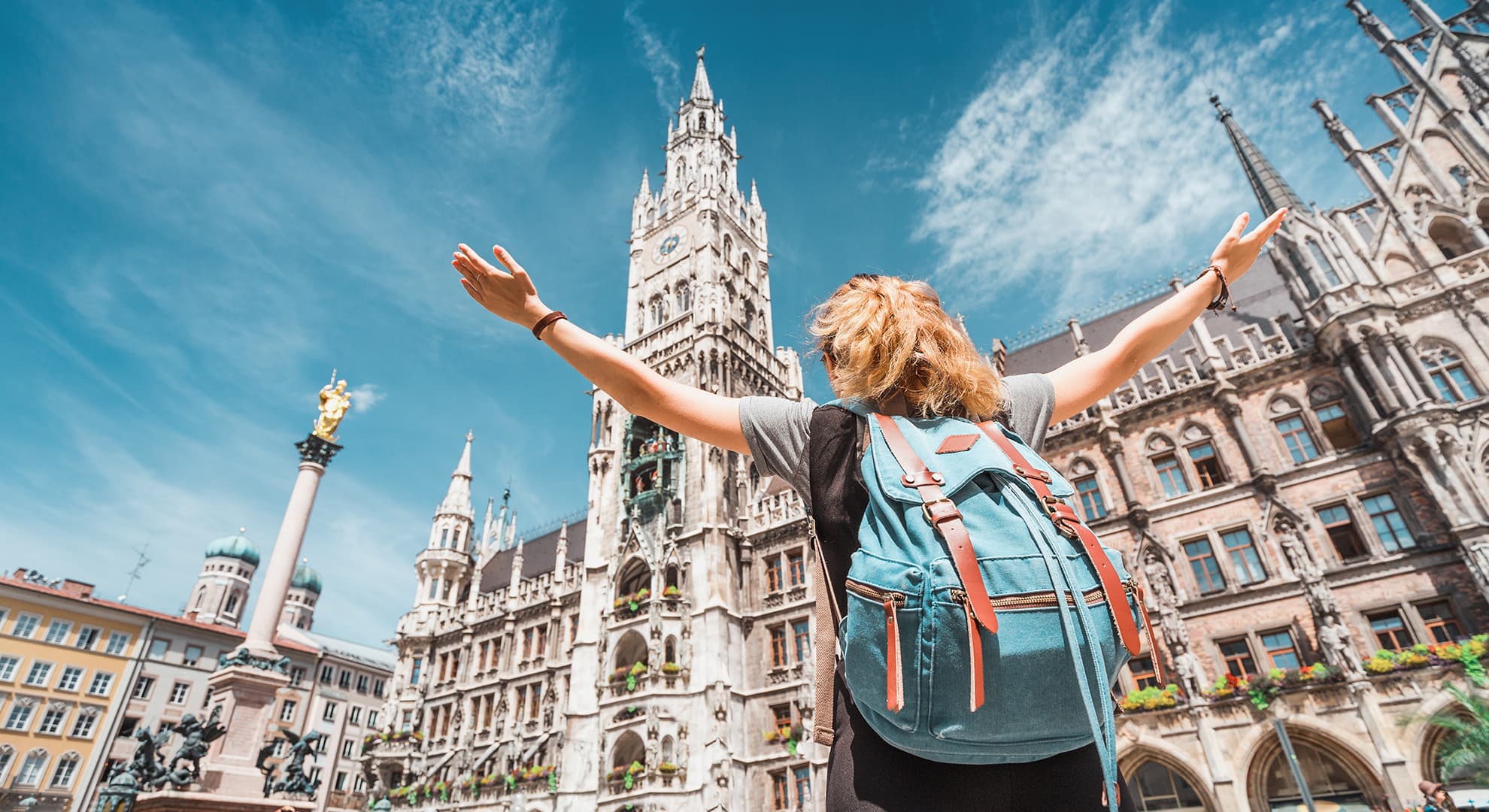 Female student with backpack discovers the old town hall in Munich, Germany