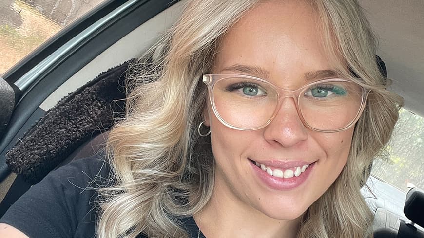 Layla Broavich wears glasses and has curled blonde hair.