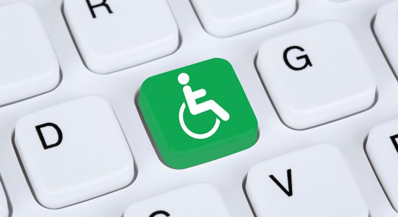Computer generated image of a keyboard with one key replaced with the green disability access person in a wheelchair symbol.