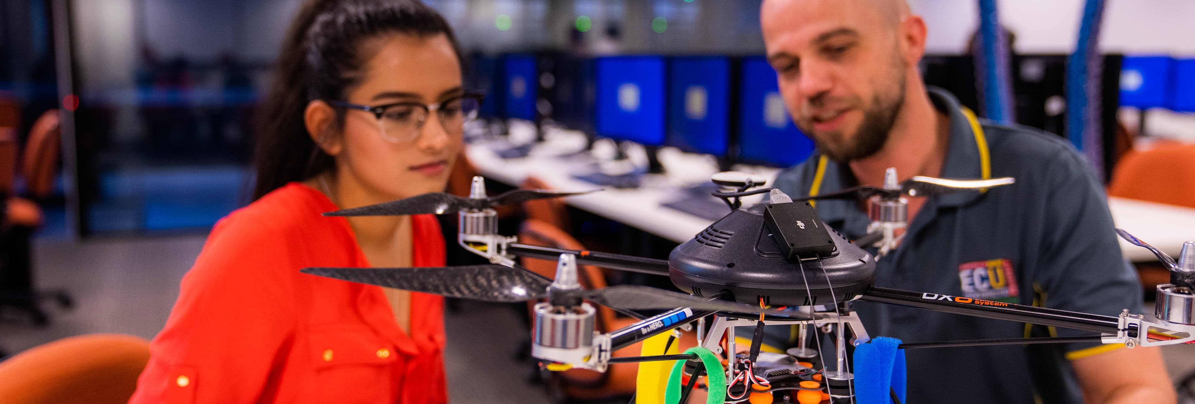 Man and woman looking at a drone