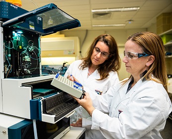 Scientists load samples into autosampler tray.