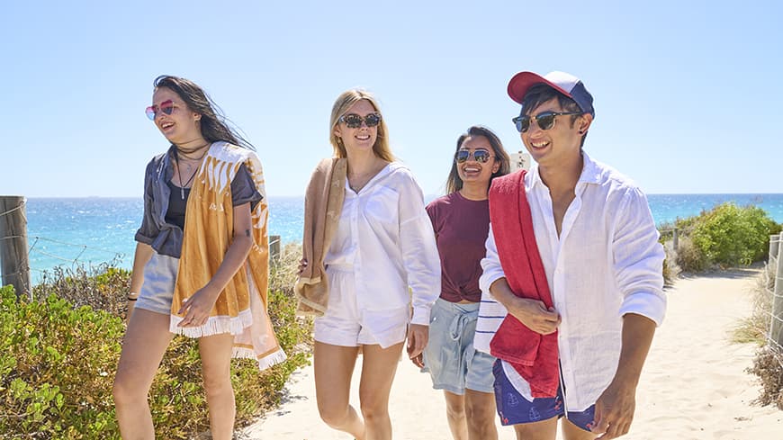 Four young students leaving the beach