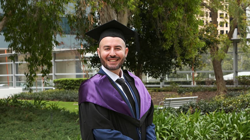 Alvaro Valdes Salazar is dressed in full regalia and cap at his graduation ceremony.