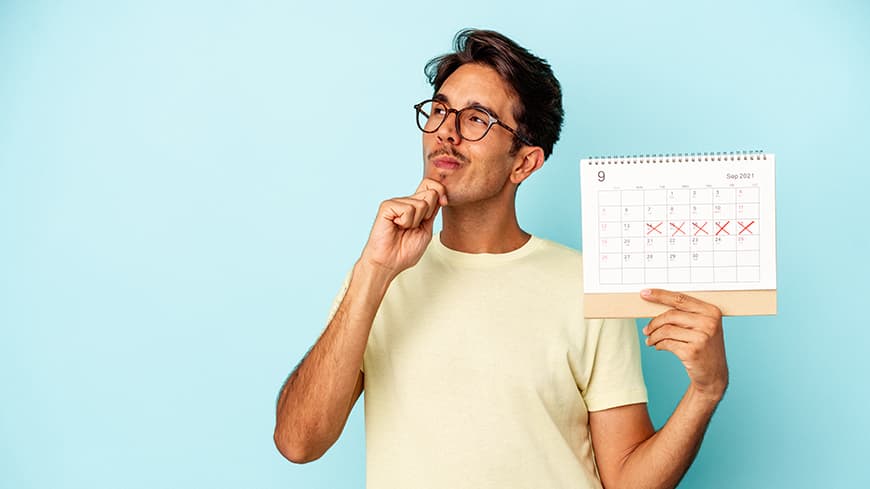 Young man holding up a calendar