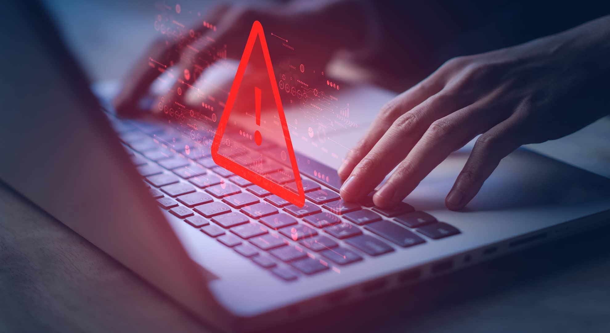 Hands using a computer with warning graphic