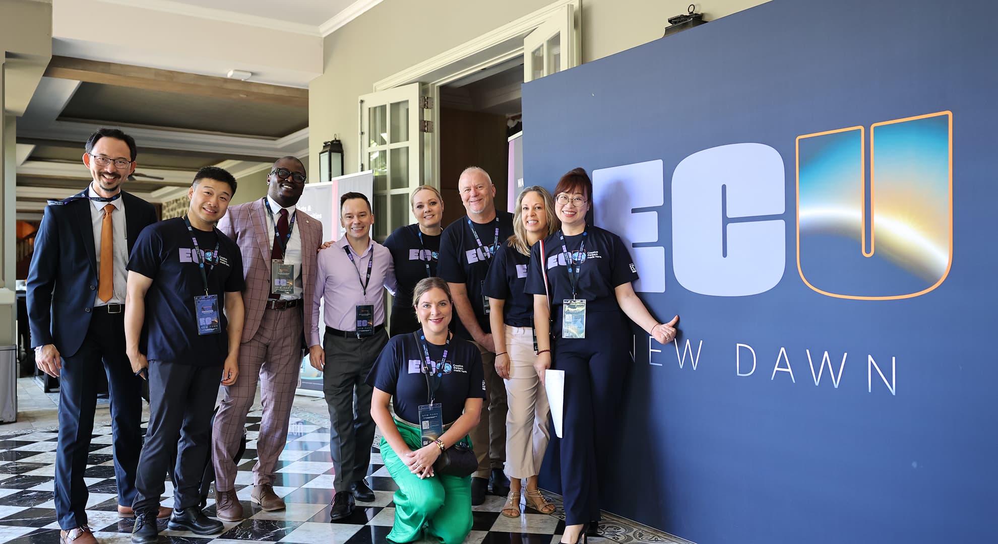 International team standing in front of New Dawn banner